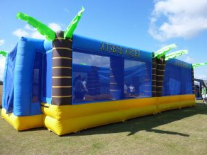 Inflatable sports arena with a group of school children playing bouncy volleyball inside.