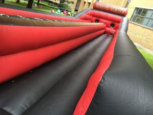 Closeup of the inflatable bungee run game set up on a field at a college event.