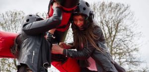 Closeup of two girls holding pugil sticks on an inflatable gladiator joust game.