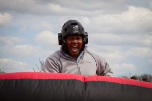 A very happy man cheering on the inflatable gladiator joust game.