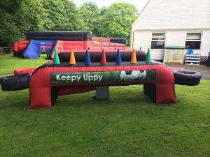 Keepy Uppy inflatable game set up for a corporate event on a grass field.