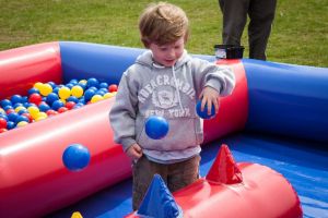 Boy playing with ball pit balls on an inflatable game.