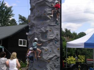 Thumbnail of a mobile climbing wall being ascended by children while two adults watch and support them