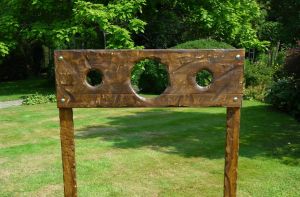 Medieval stocks set up for an event in a garden.