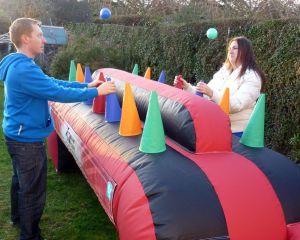 Inflatable under pressure game played by a male and female in a garden for a family fun day event.